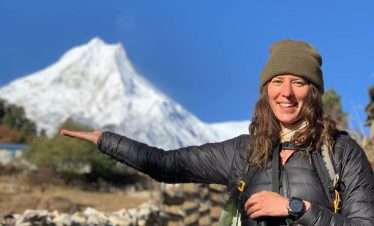Female trekker holding Mount Manaslu peak on her hand – Manaslu Circuit Trek, Nepal.