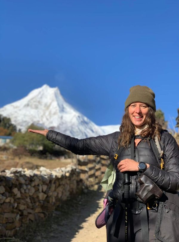 Female trekker holding Mount Manaslu peak on her hand – Manaslu Circuit Trek, Nepal.