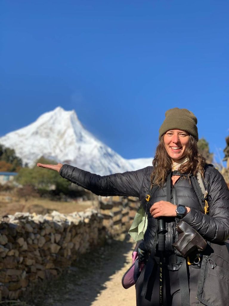 Female trekker holding Mount Manaslu peak on her hand – Manaslu Circuit Trek, Nepal.