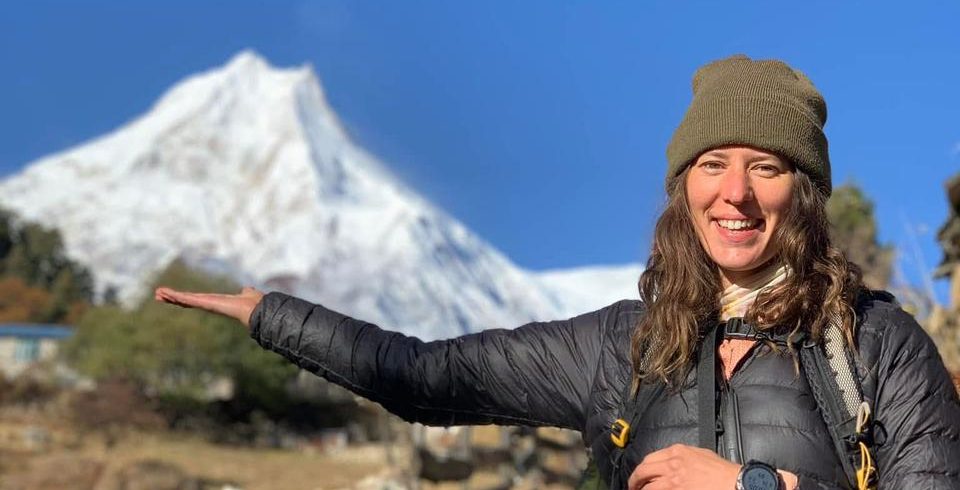 Female trekker holding Mount Manaslu peak on her hand – Manaslu Circuit Trek, Nepal.