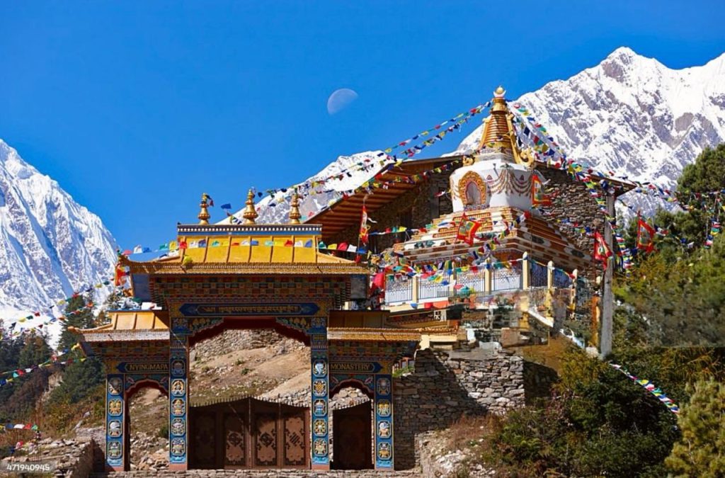 Buddhist monastery in Manaslu region with snowcapped Himalayan mountains.