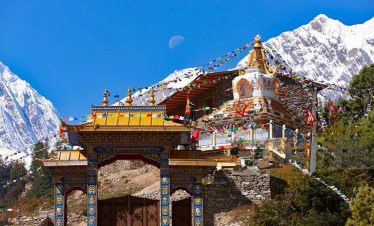Buddhist monastery in Manaslu region with snowcapped Himalayan mountains.