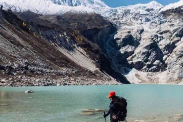 Trekker standing beside a Birendra glacial lake.