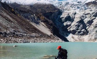 Trekker standing beside a Birendra glacial lake.
