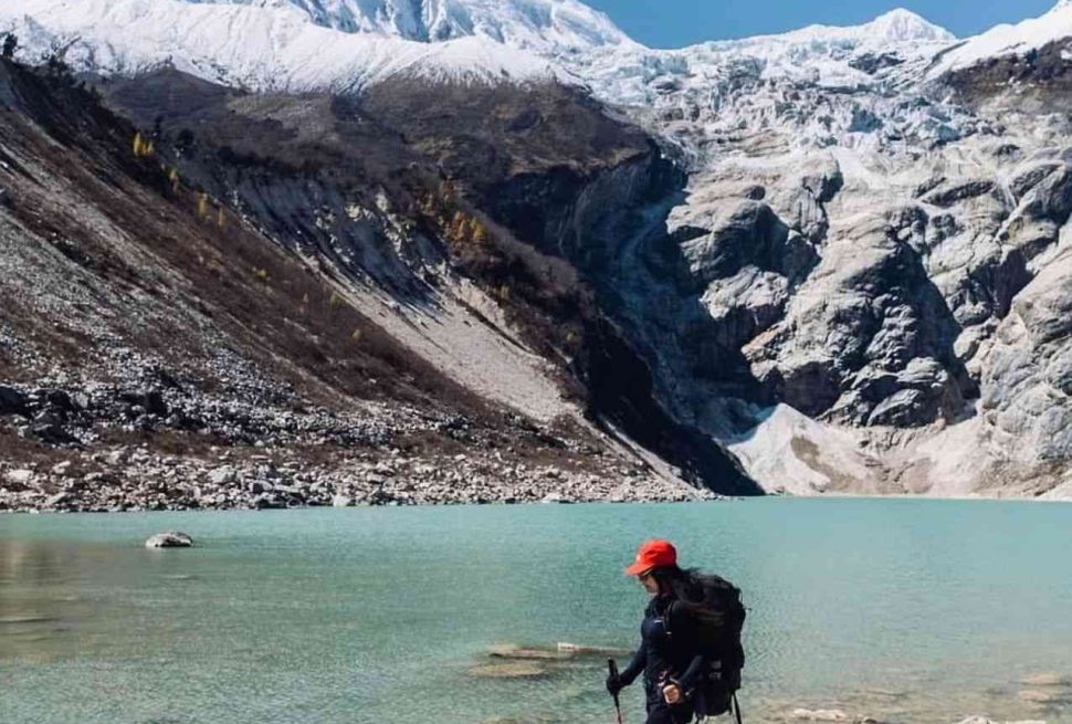Trekker standing beside a Birendra glacial lake.