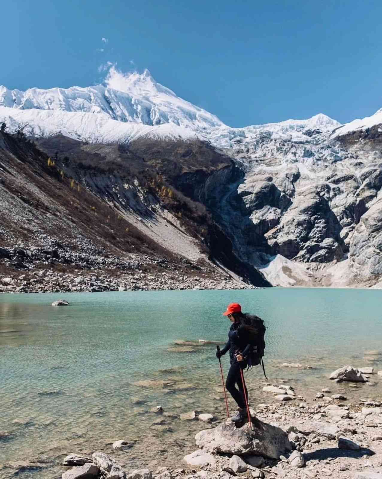 Trekker standing beside a Birendra glacial lake.