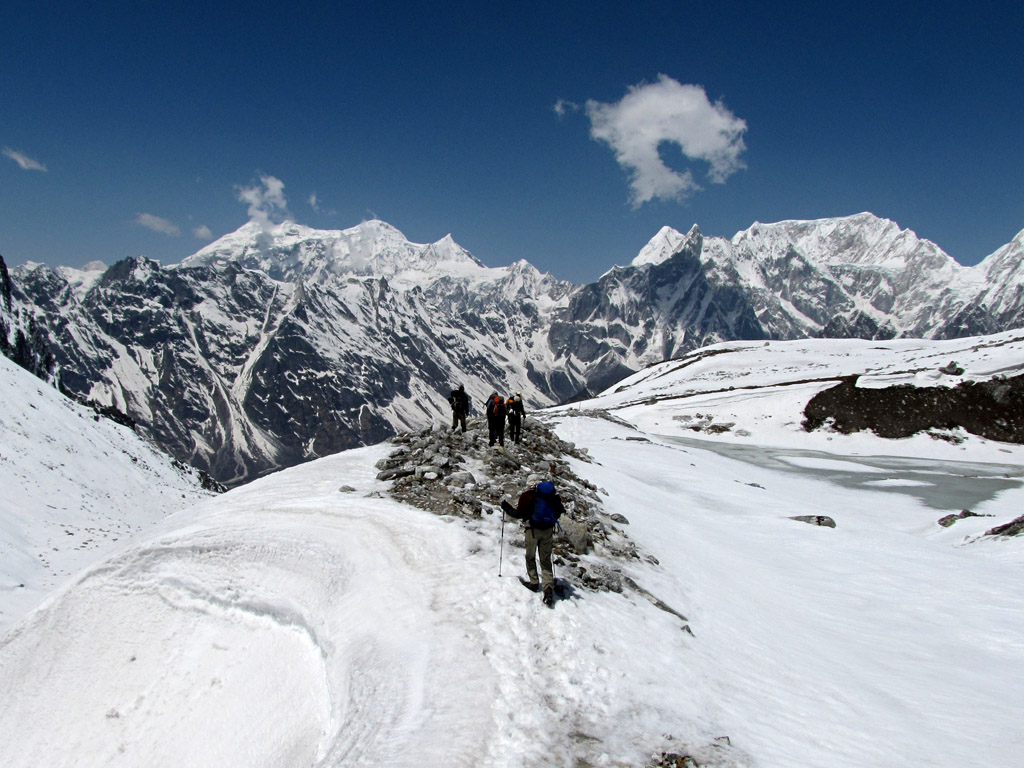 Trekkers crossing snow-covered Larkya La Pass on the Manaslu Circuit trek