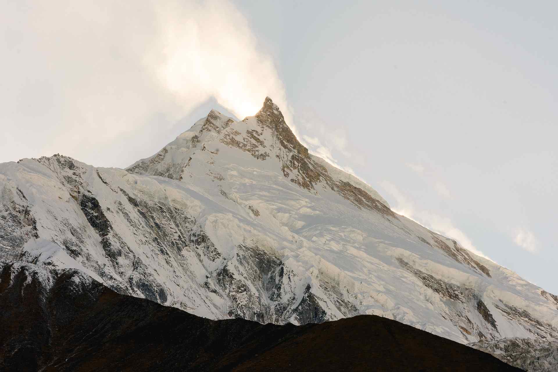 Snow-capped Mount Manaslu peak glowing at sunrise in the Himalayas, Nepal.