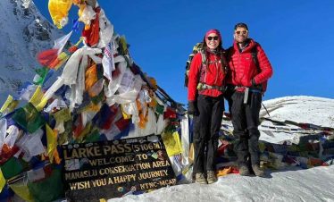 Trekkers standing with Mount Manaslu in the background during the Manaslu Circuit and Tsum Valley Trek.