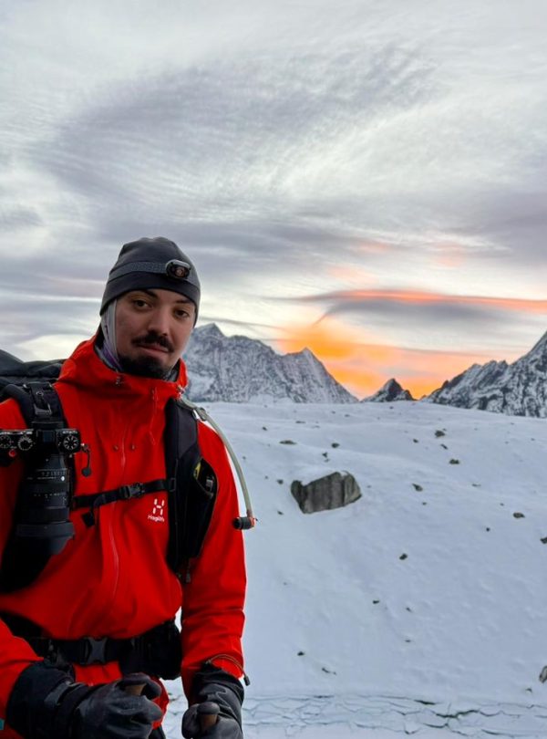 Trekker walking on a snowy trail on the way to Manaslu Larkya Pass with Himalayan peaks in the background during Manaslu Circuit Trek