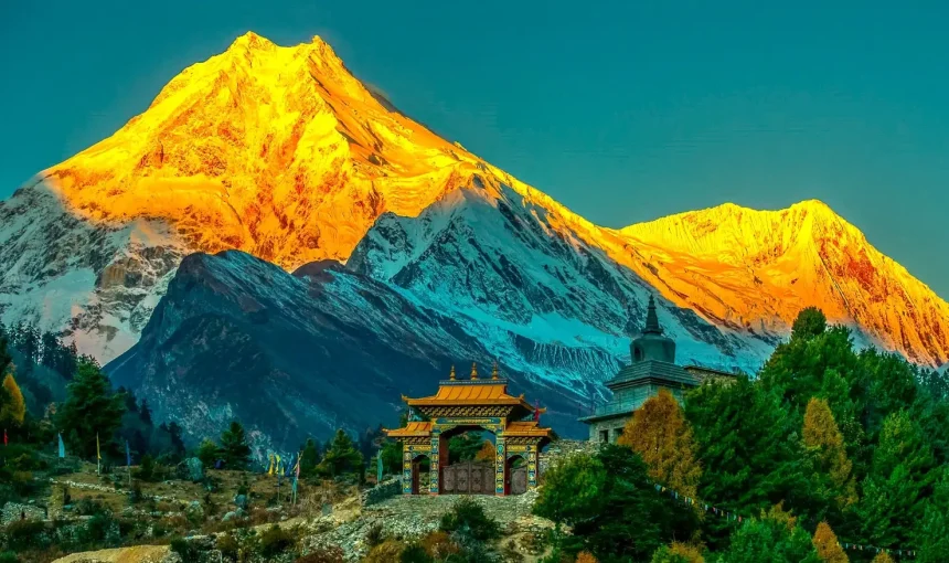 Sunrise view of Mount Manaslu with monastery and green hills on Manaslu Circuit trek Nepal