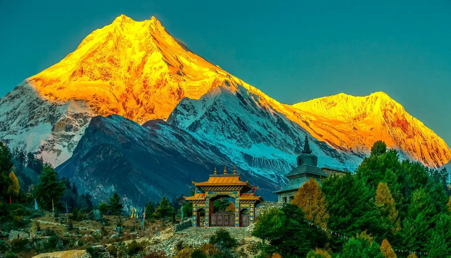 Sunrise view of Mount Manaslu with monastery and green hills on Manaslu Circuit trek Nepal