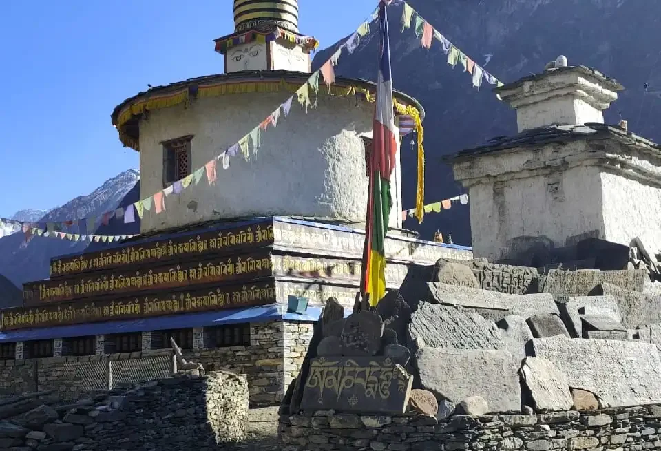 Quiet trail with a whitewashed chorten and prayer flags on the Manaslu Tsum Valley Trek in Nepal